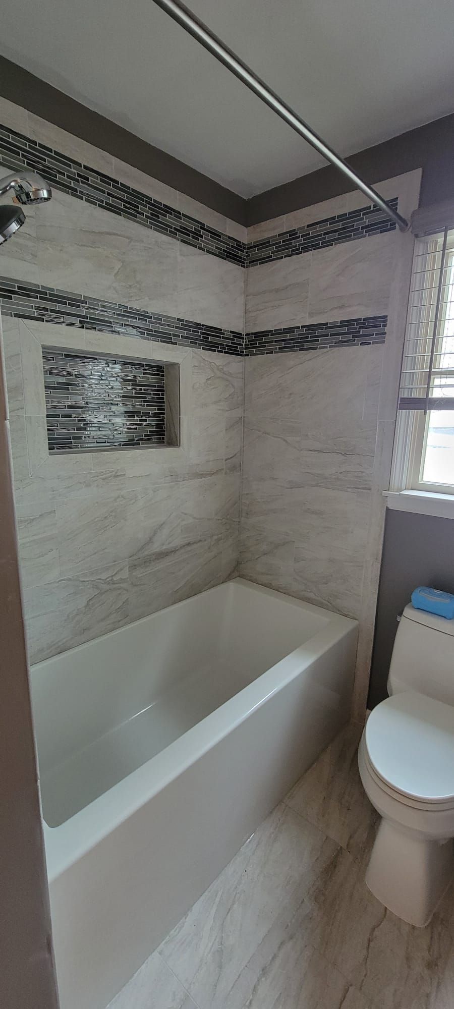 A bathroom with a tub , toilet and shower.