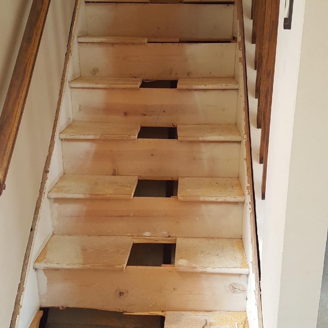 A set of wooden stairs with a wooden railing