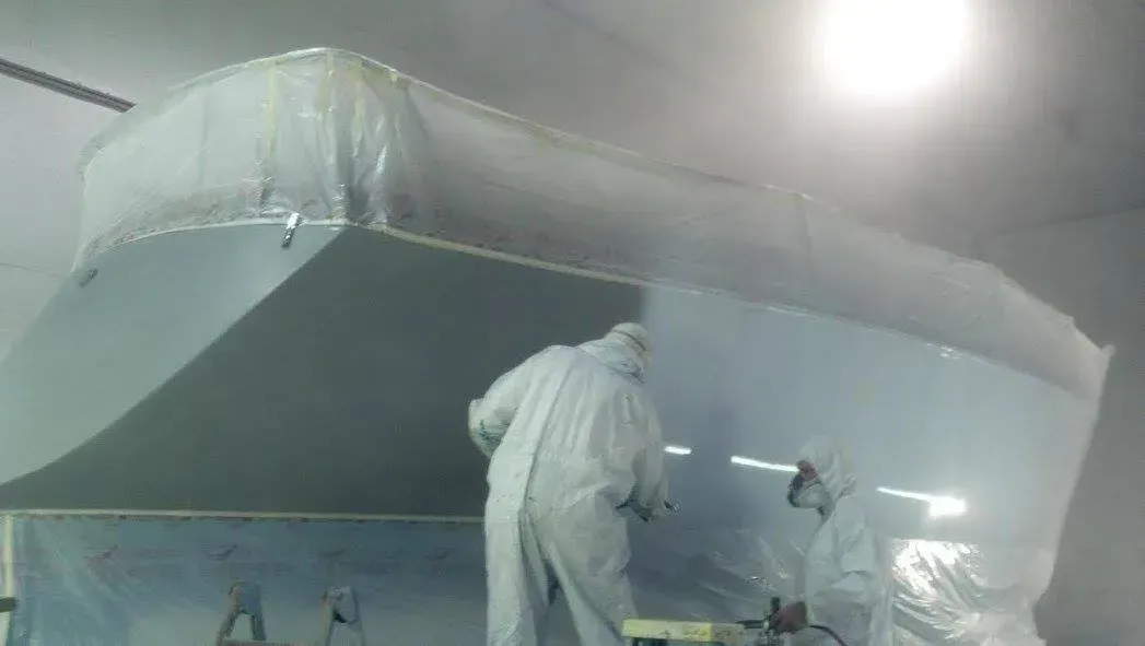 A group of people in white suits are working in a room covered in plastic.