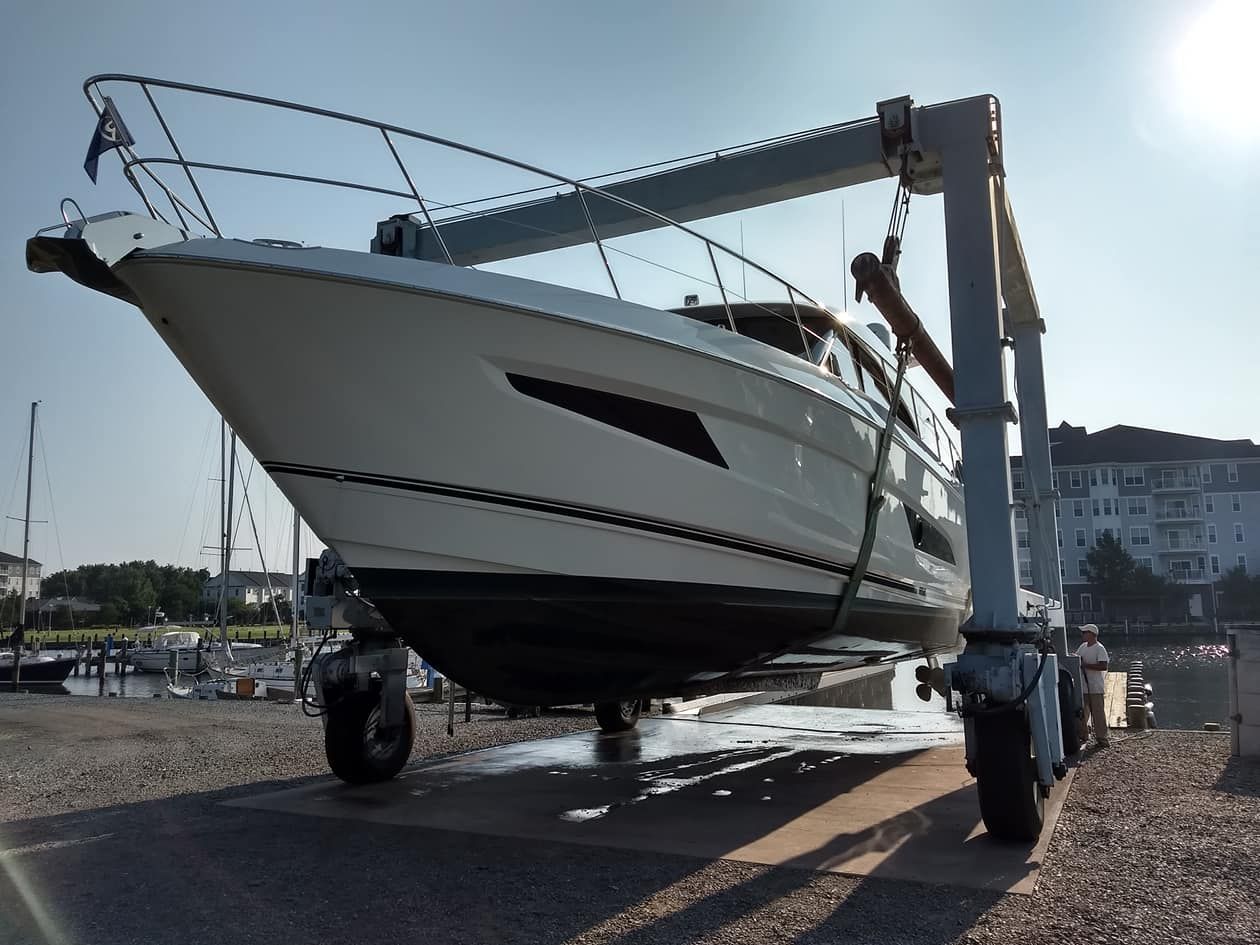 A large white boat is being lifted by a crane