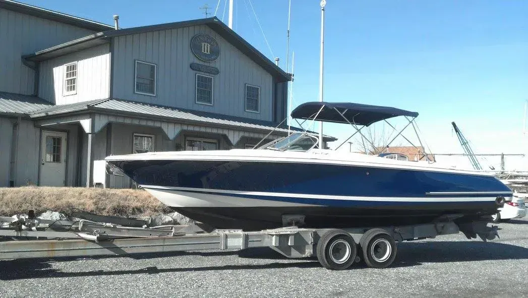 A boat is sitting on a trailer in front of a building.