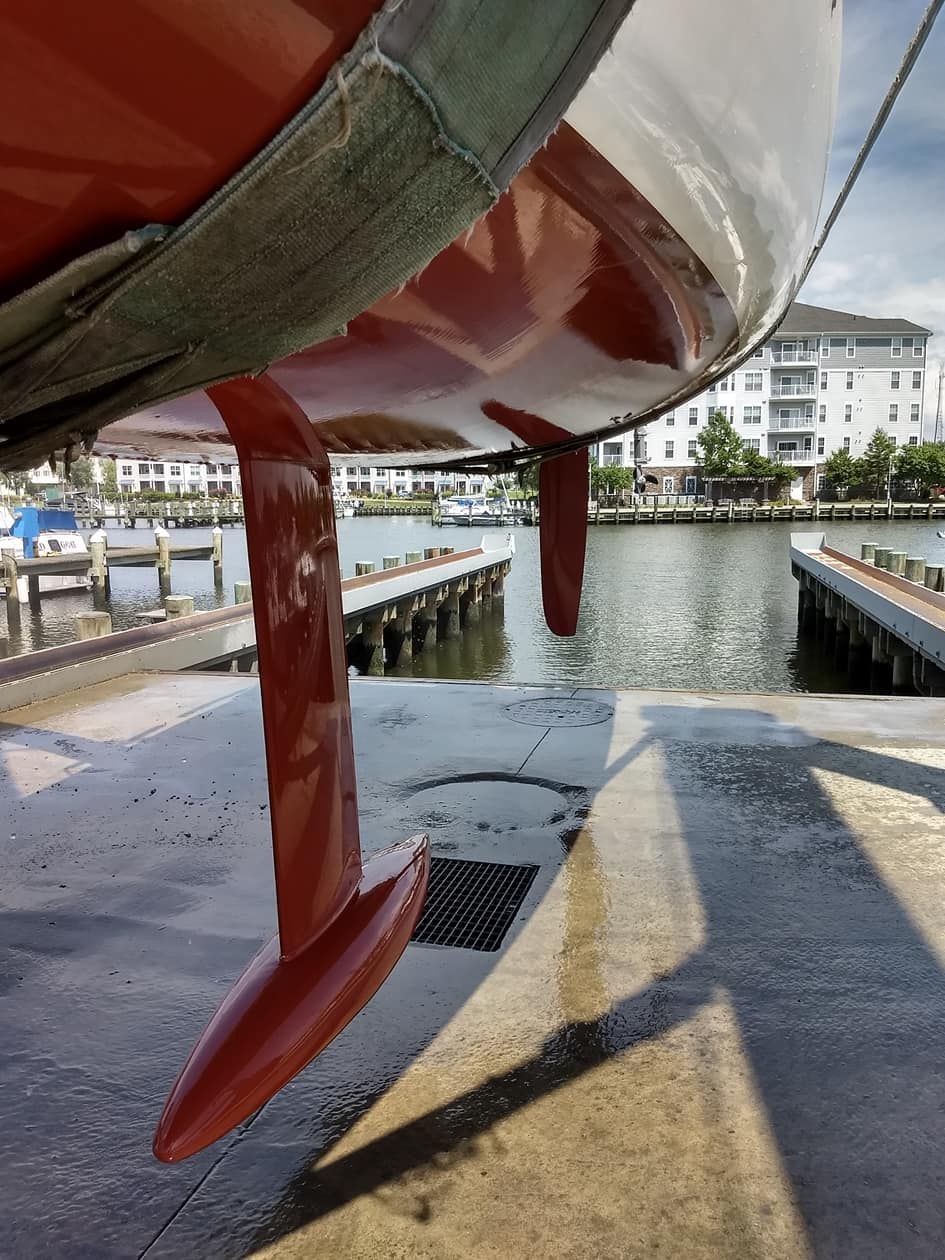 A red and white boat is docked at a dock.