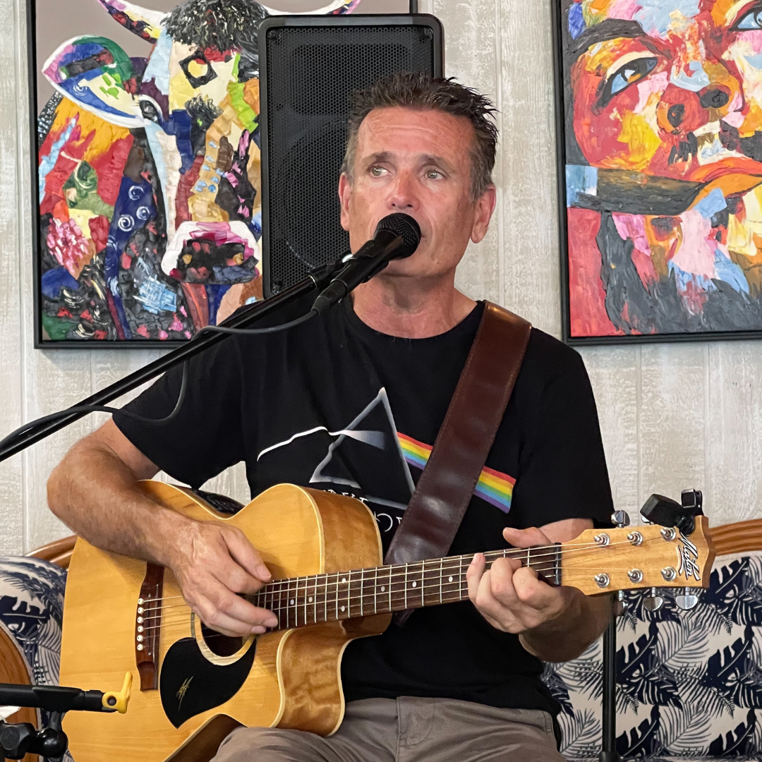 A Man Is Singing Into a Microphone While Playing a Guitar — Chop 'n Chill in Port Macquarie, NSW