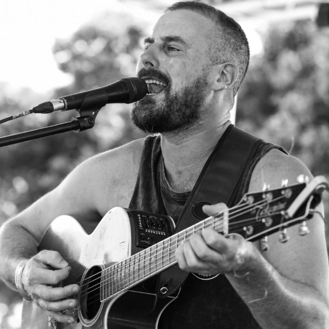 A Man Singing Into a Microphone While Holding a Guitar — Chop 'n Chill in Port Macquarie, NSW