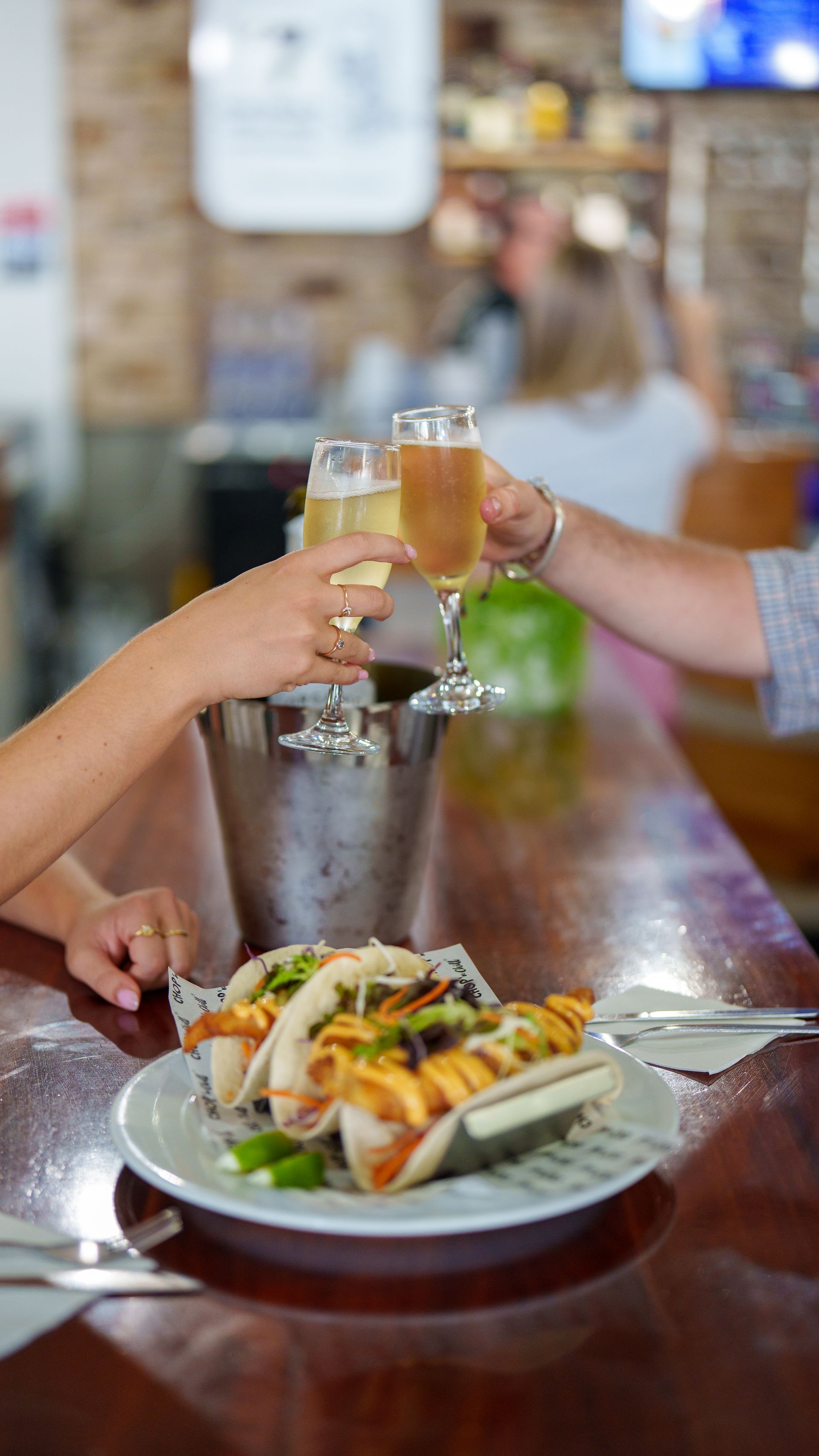 Senior Couple Are Sitting At A Table Toasting With Wine Glasses — Chop 'n Chill in Port Macquarie, NSW