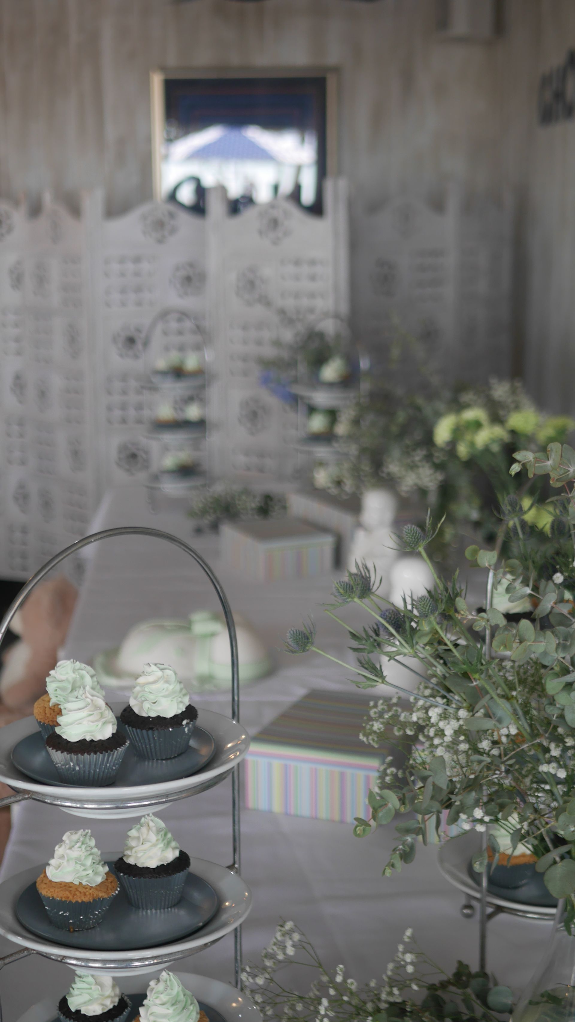 A Display of Cupcakes on A Table with Flowers in The Background — Chop 'n Chill in Port Macquarie, NSW