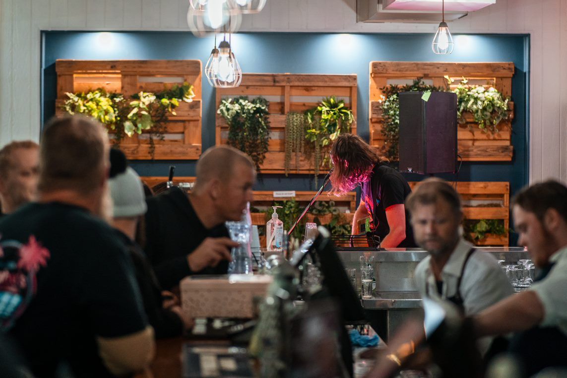 A Group of People Are Sitting at A Table in A Restaurant — Chop 'n Chill in Port Macquarie, NSW