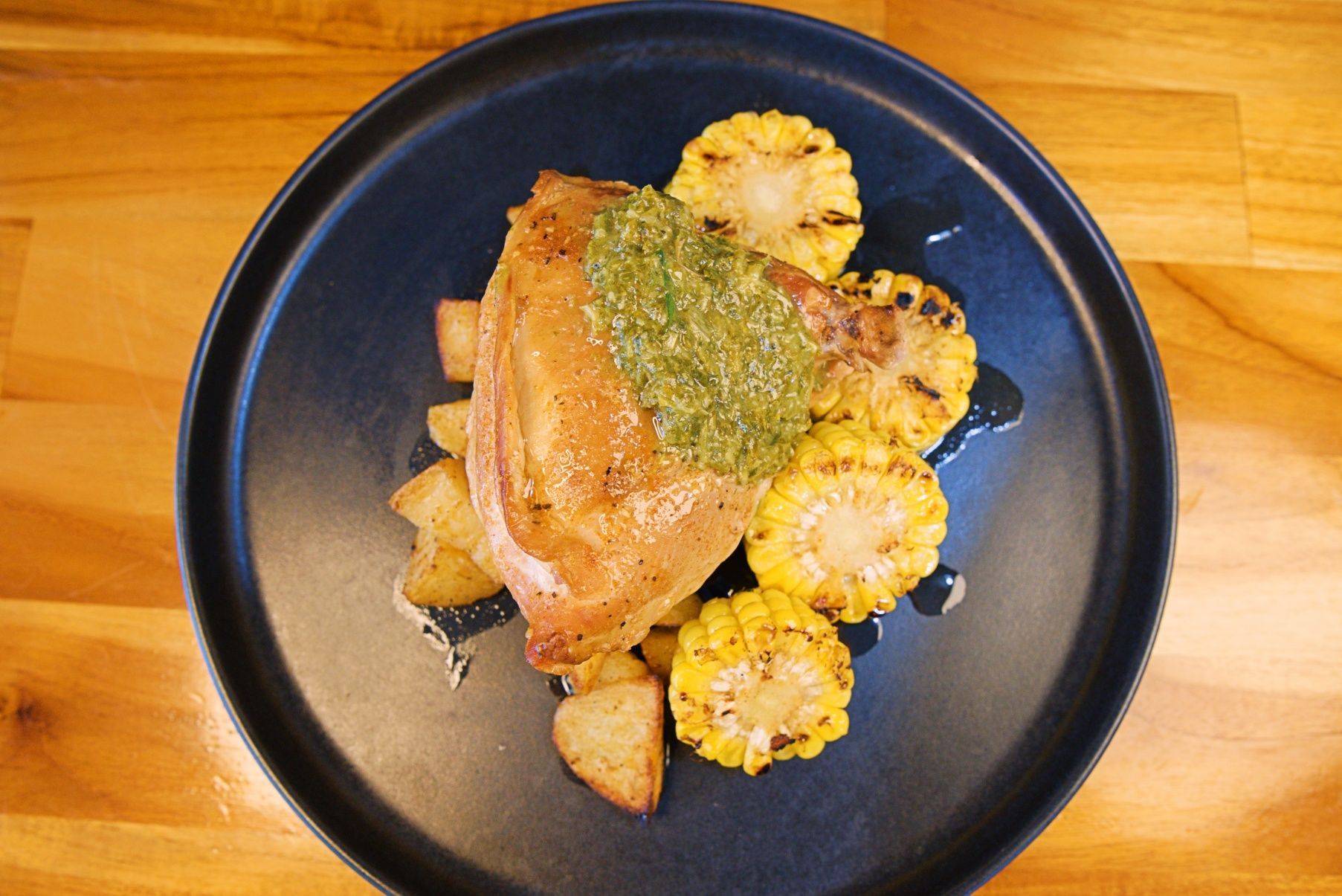 Grilled Chicken Breast With Pesto, Potato Wedges, and Grilled Corn on a Blue Plate — Chop 'n Chill in Port Macquarie, NSW