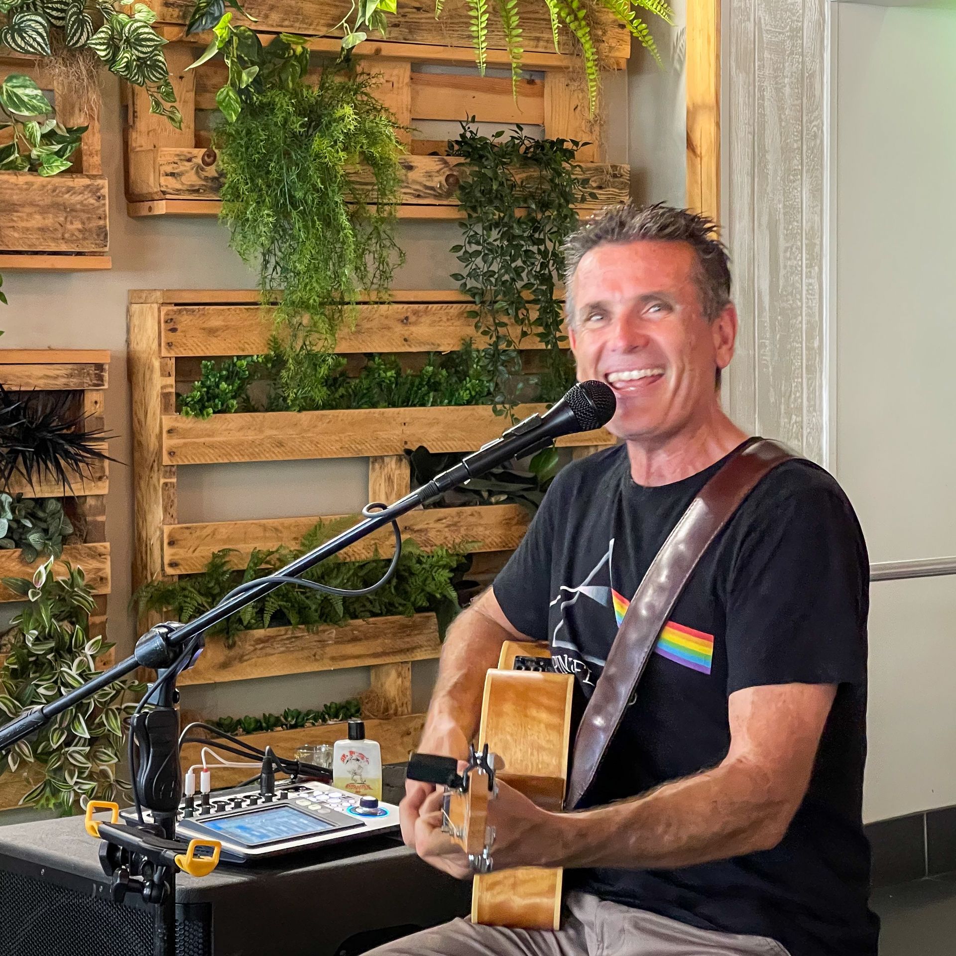 A Man Is Playing a Guitar and Singing Into a Microphone — Chop 'n Chill in Port Macquarie, NSW