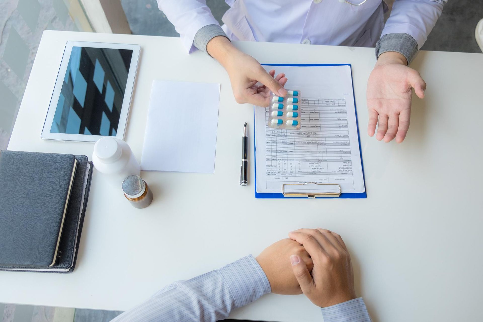 Family of three embracing near a waterfront; child in arms, adults smiling, cityscape background.