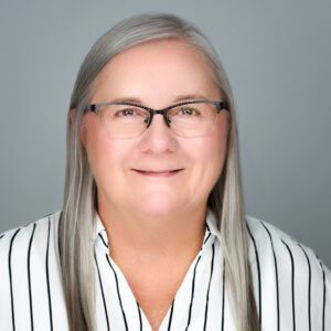 A family is sitting on a red couch in front of a christmas tree.