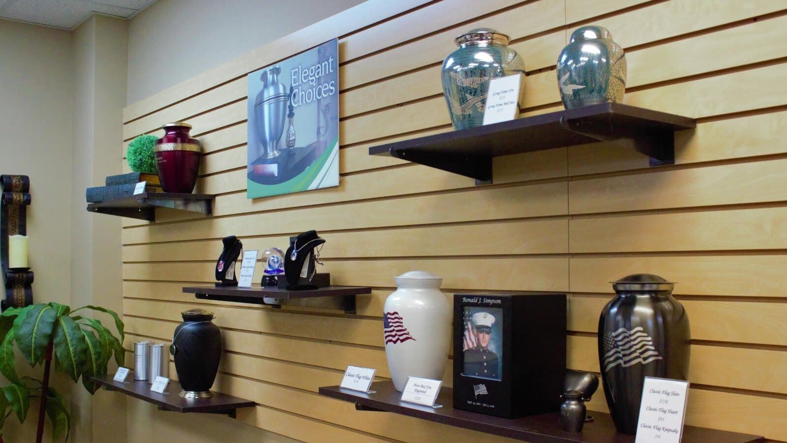 Shelved urns and vases displayed on a wall in a store or gallery.