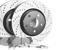 Two slotted and drilled brake rotors with brake pads and brake lines, grayscale. | Kensington Motor Cars