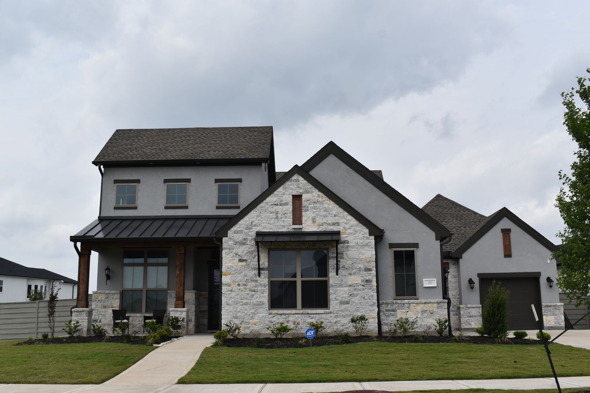 A large house with a lot of windows is sitting on a lush green lawn.