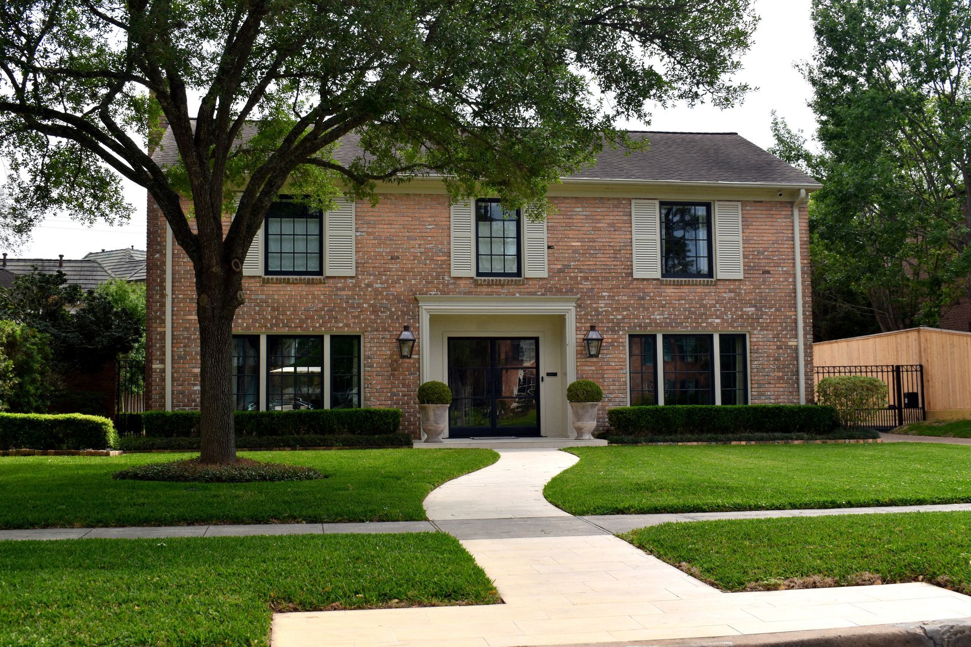 A large brick house with white shutters on the windows
