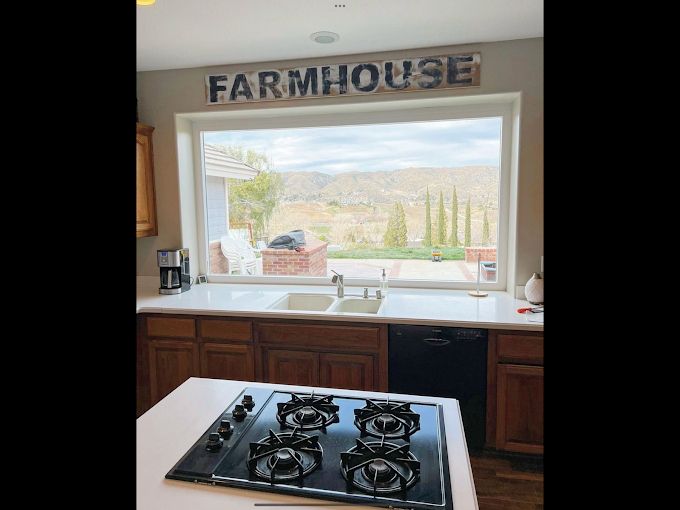 Kitchen with a large window overlooking a landscape. 