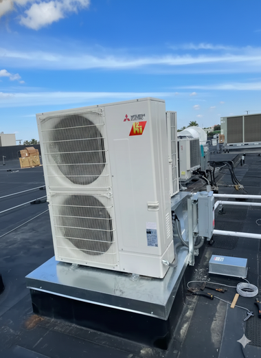 Mitsubishi HVAC unit on a rooftop, with other units in the background under a blue sky.