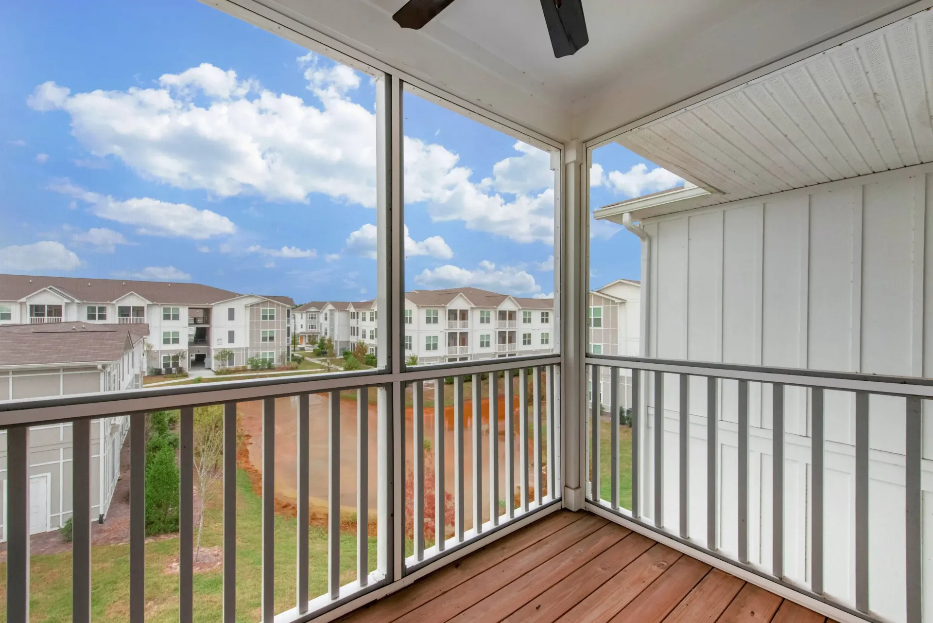 Balcony view overlooking a white, multi-building apartment complex