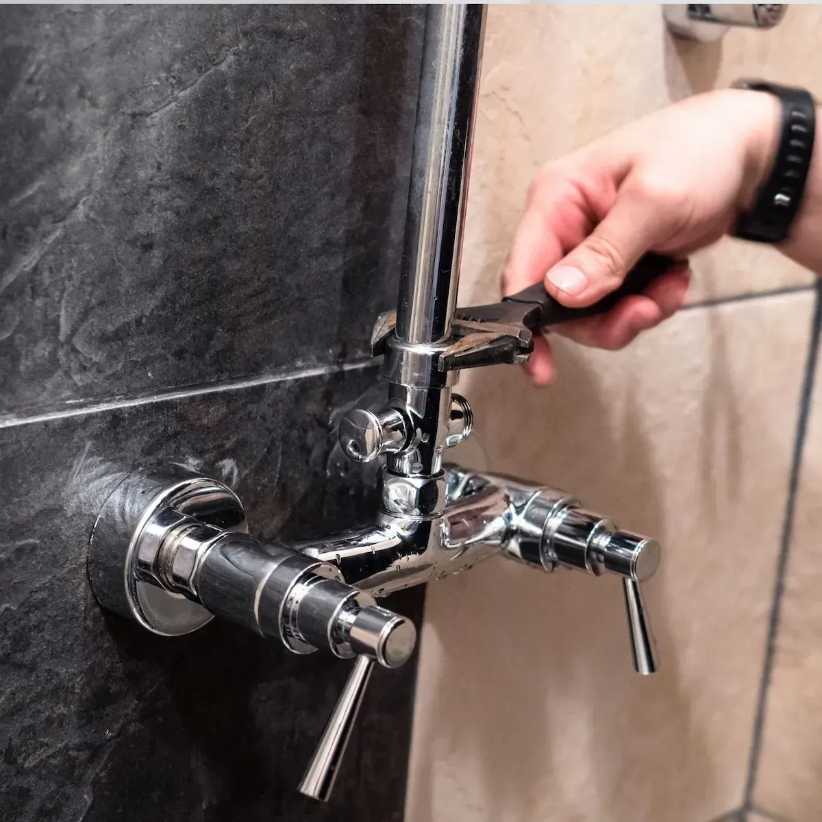 Close-up of a plumber adjusting a shower valve in Commerce City.