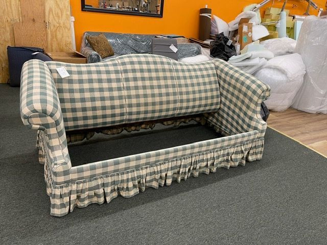 A checkered couch is sitting on a carpet in a room