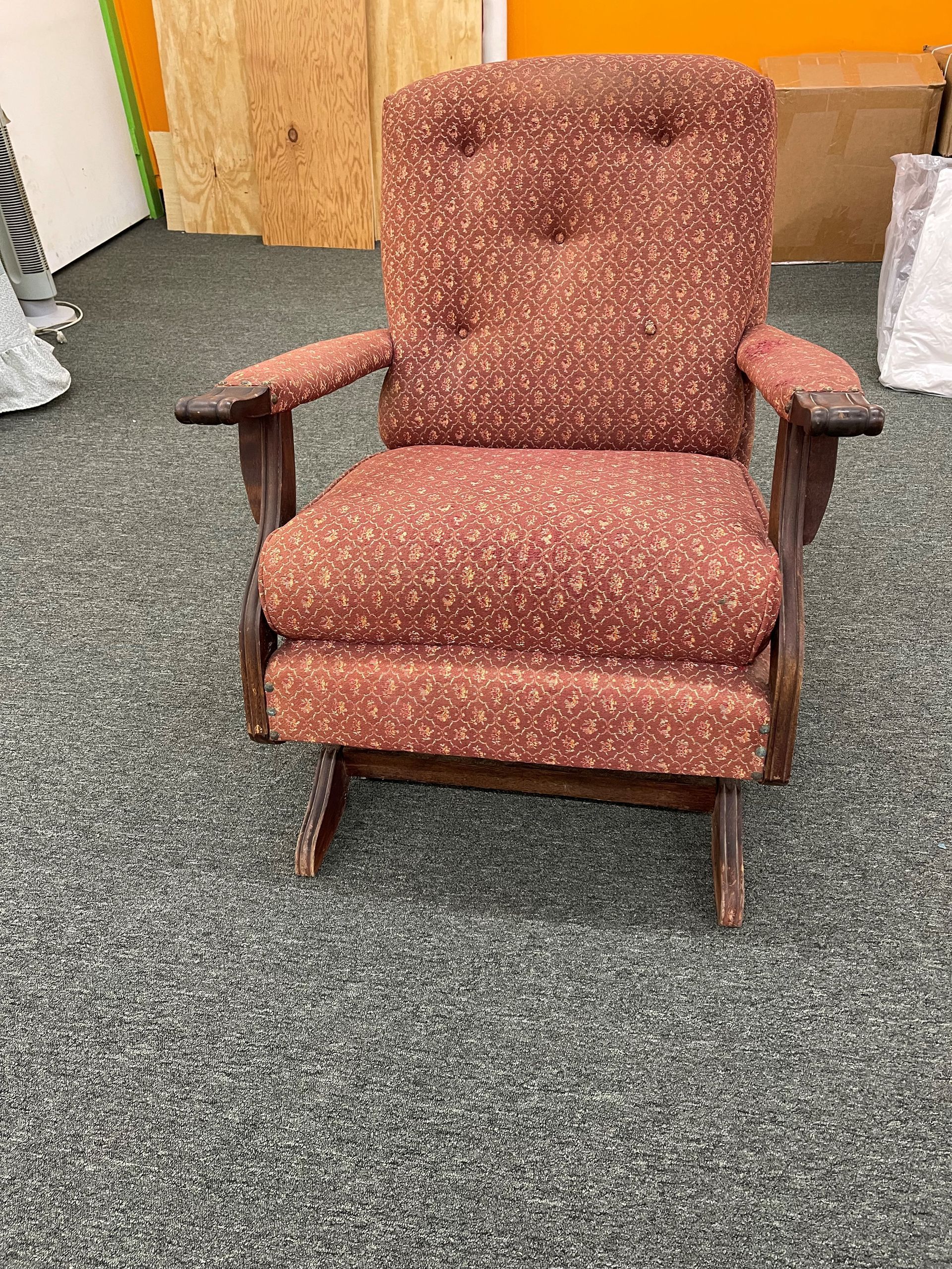 A rocking chair is sitting on a carpeted floor in a room.