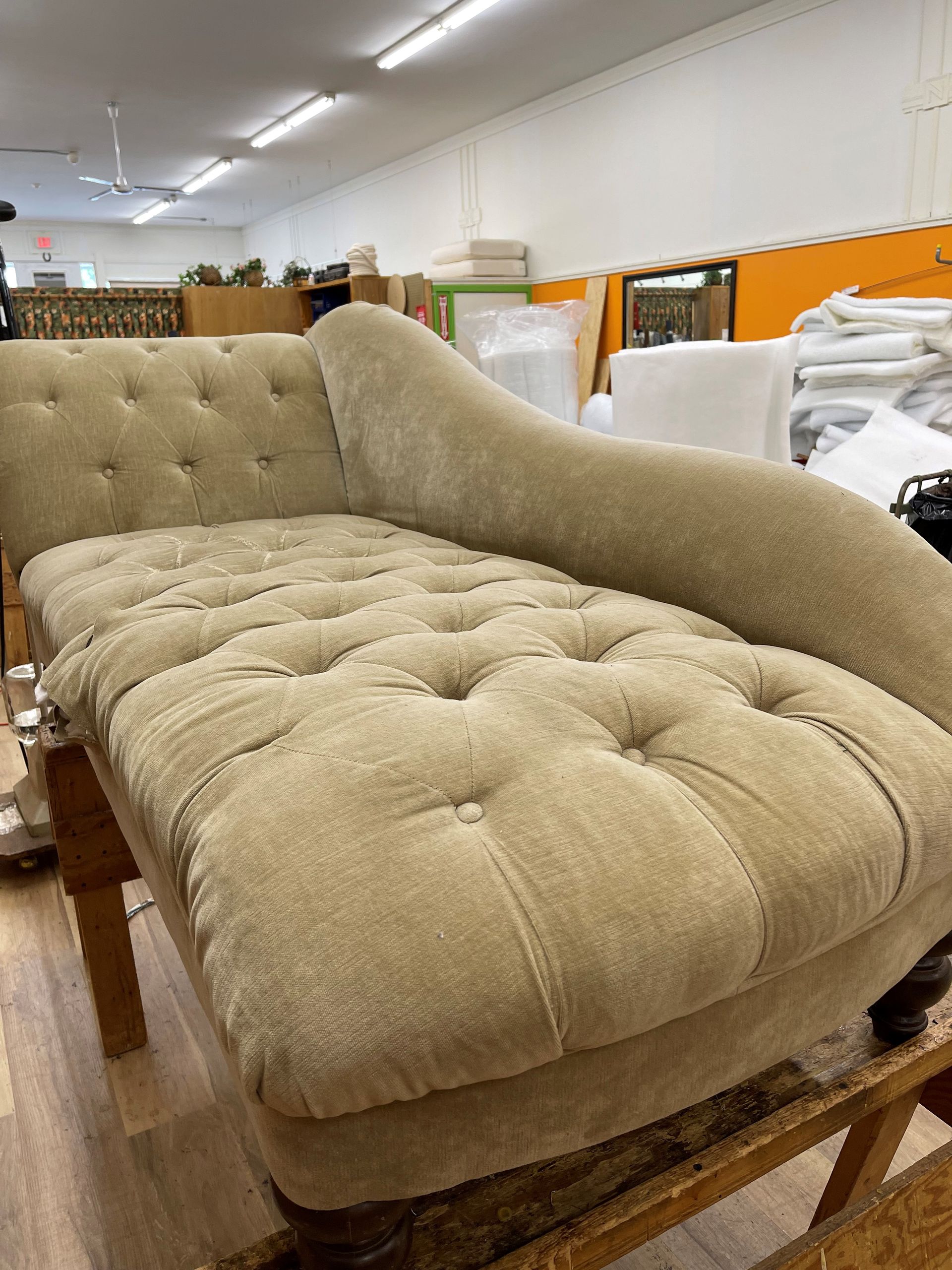 A chaise lounge is sitting on a wooden table in a room.