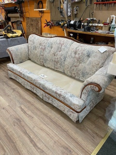 A couch is sitting on a wooden floor in a room.