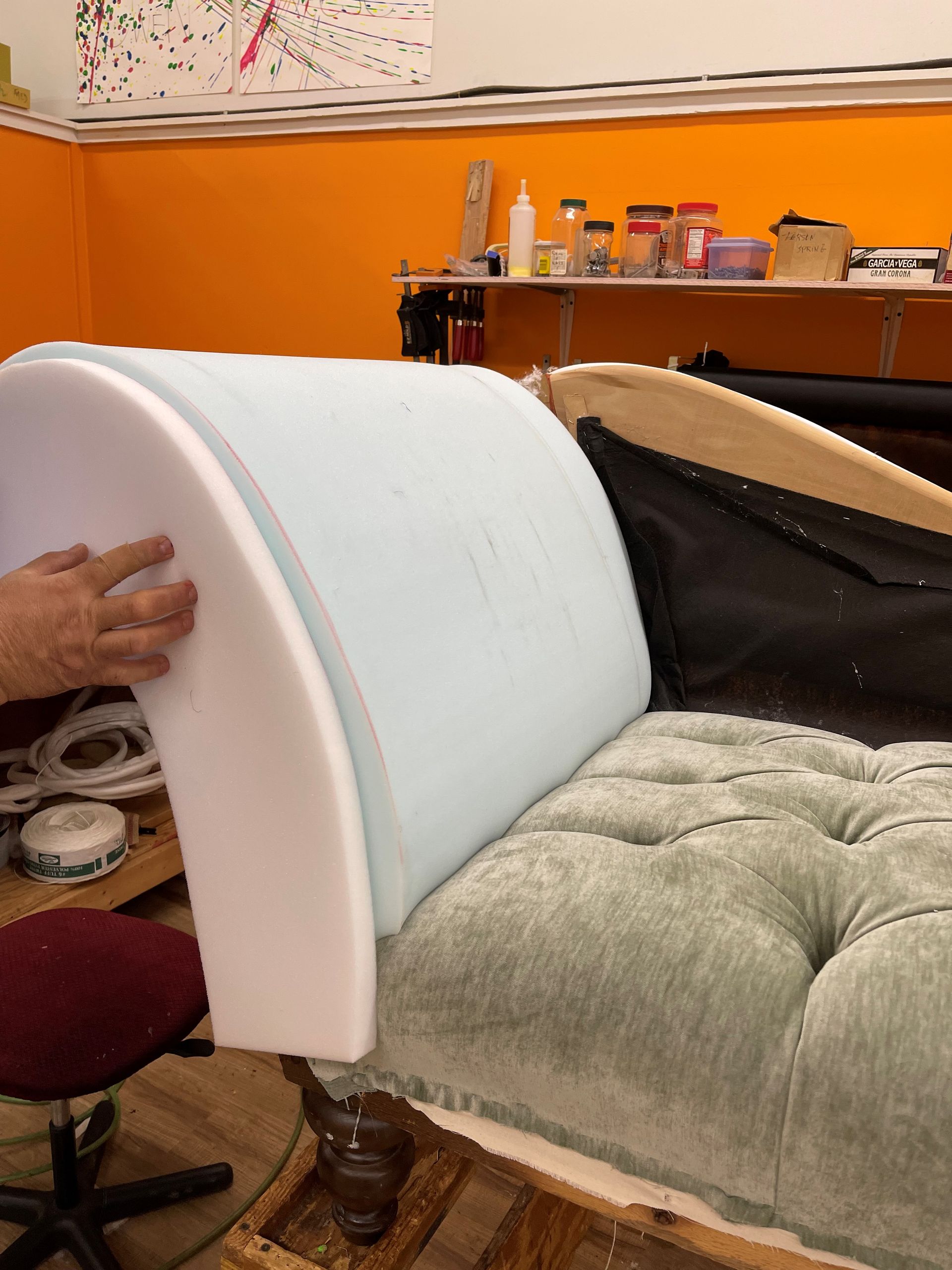 A person is holding a piece of foam on a couch