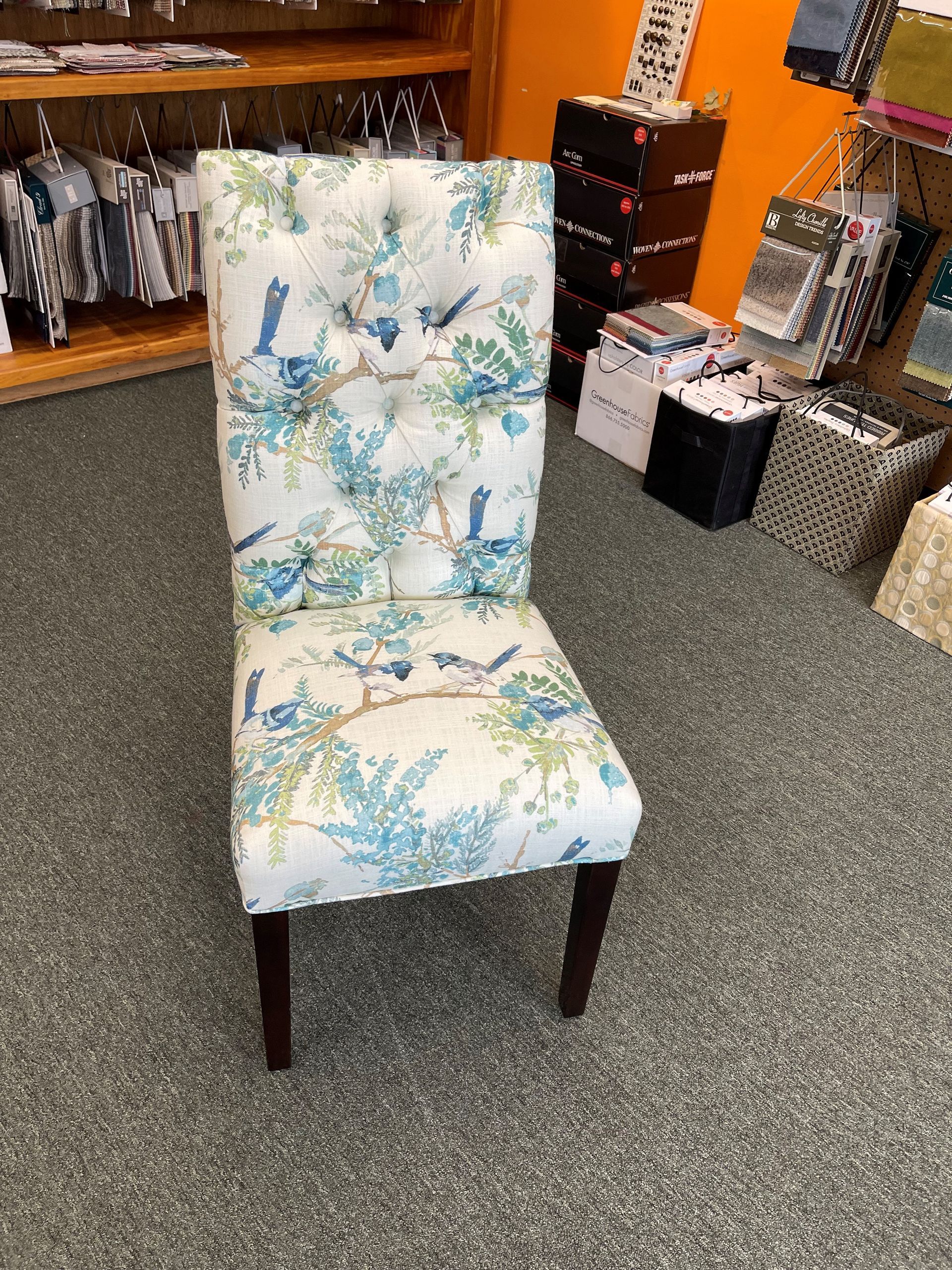 A chair with a blue and white floral pattern is sitting in a room.