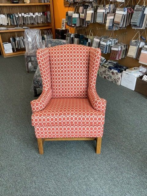 A red chair with a pattern on it is sitting in a room.
