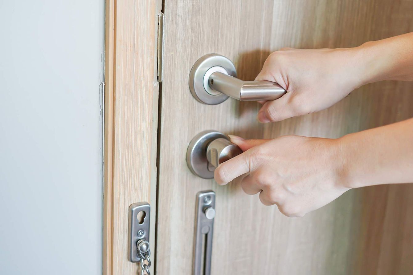 A person is opening a door with their hands.