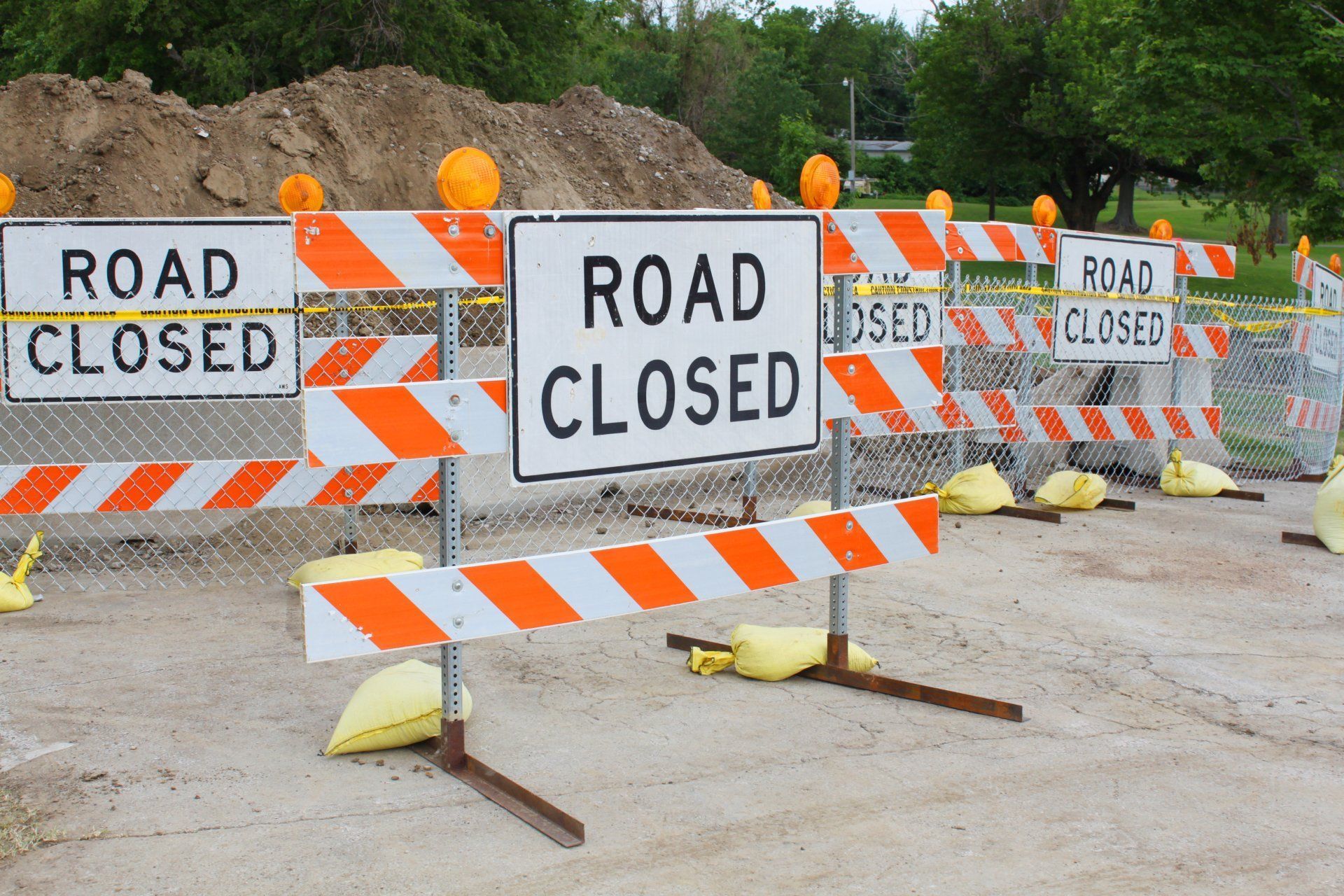 A row of orange and white road closed signs