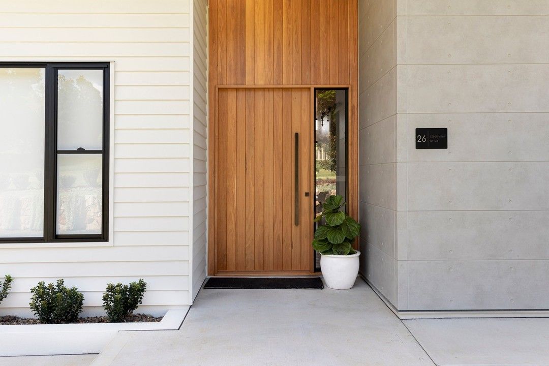 The Front Door of A House with A Wooden Door and A Potted Plant in Front of It — Bootle Timber QLD Pty Ltd in Garbutt, QLD