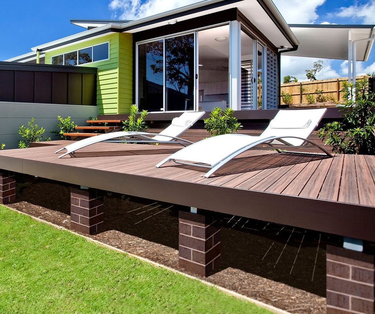 A Brown Deck With Two Lounge Chairs— Bootle Timber QLD Pty Ltd in Garbutt, QLD