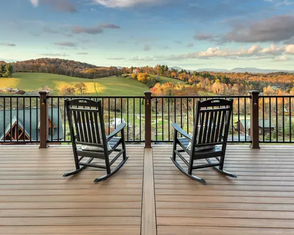 Two Rocking Chairs Are Sitting on A Wooden Deck Overlooking a Valley — Bootle Timber QLD Pty Ltd in Garbutt, QLD