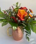 Orange rose with natural greenery in a copper mug.