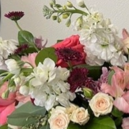 Close-up of a flower arrangement with pink, white, and burgundy blooms.