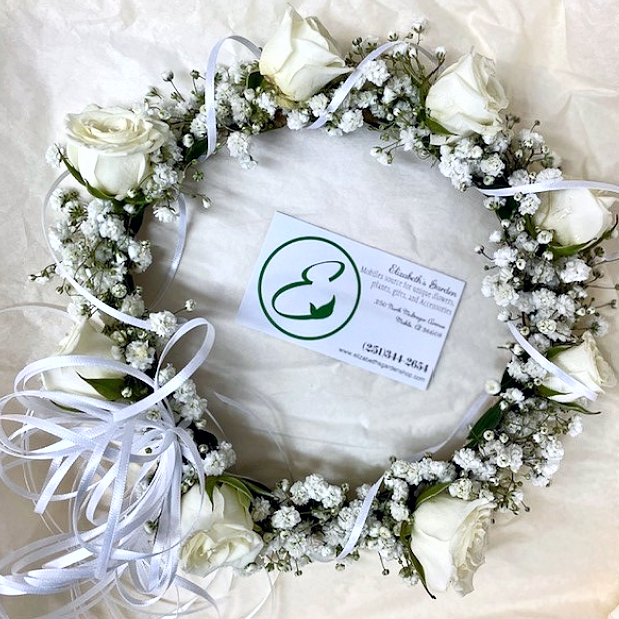 White rose and baby's breath flower crown with white ribbons. Business card in the middle.