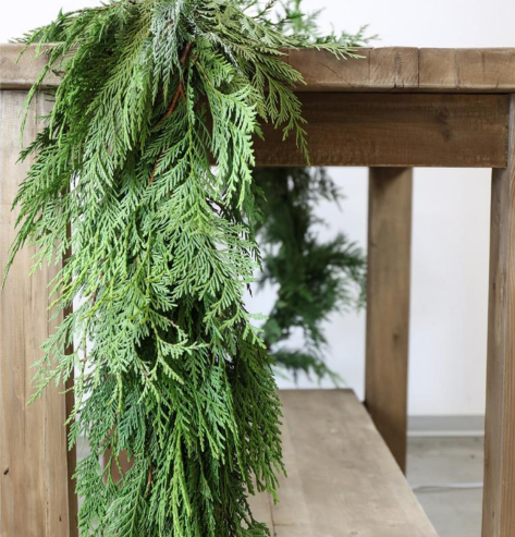 A fresh cedar garland shown hanging from a railing.