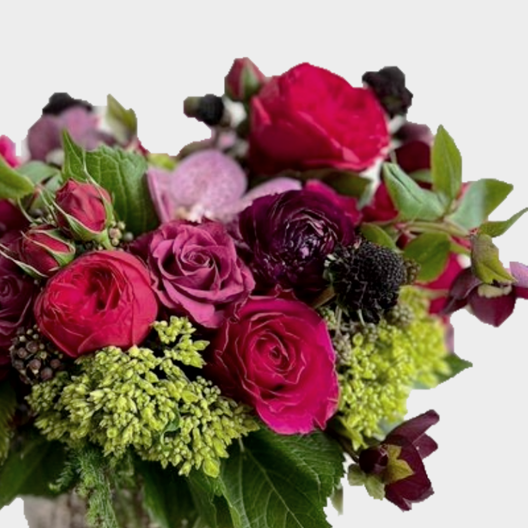 Close-up of a floral arrangement with red, purple, and green flowers.