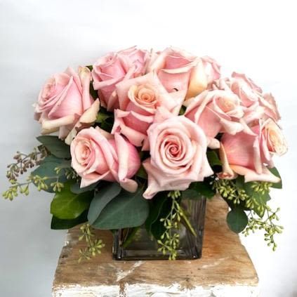 A vase filled with pink perfect roses