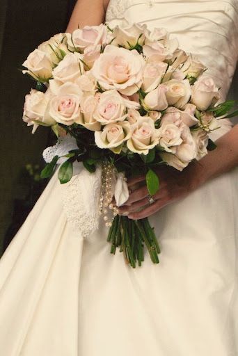 Bride holding a bouquet of light pink roses.