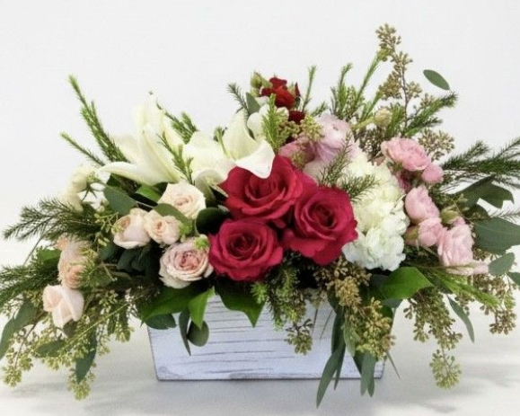 Scented floral arrangement with pink, white, and red flowers in a white ceramic container.