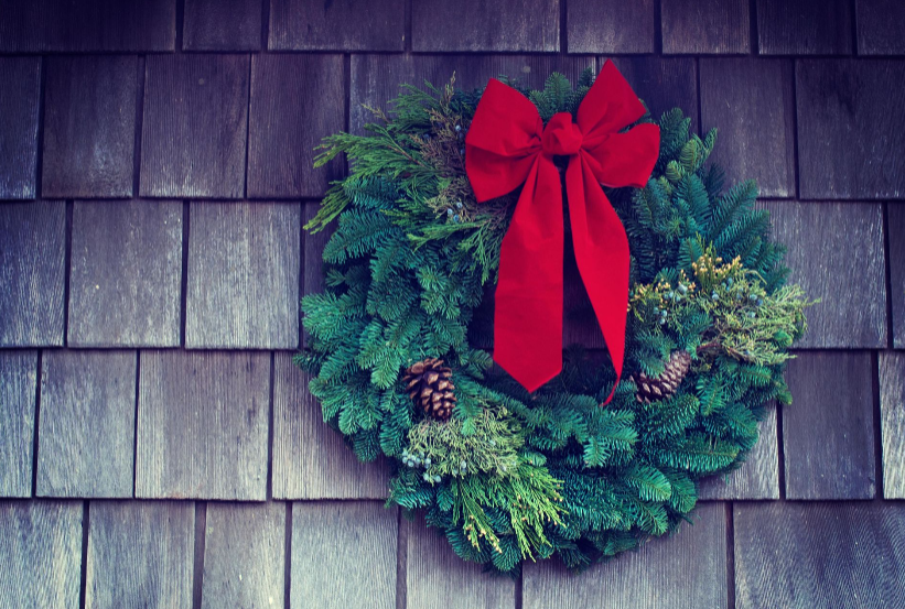 A Christmas evergreen wreath with a red bow.