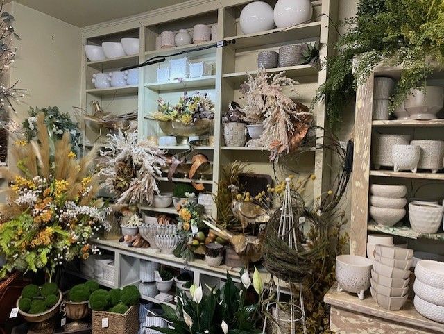 Decorative items, including vases, floral arrangements, and plants. Light and neutral colors are prominent.