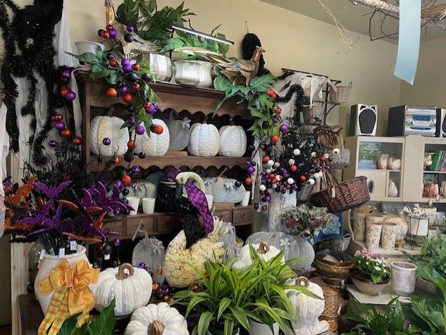 A Halloween-themed display with pumpkins, spiders, and purple and orange decorations.