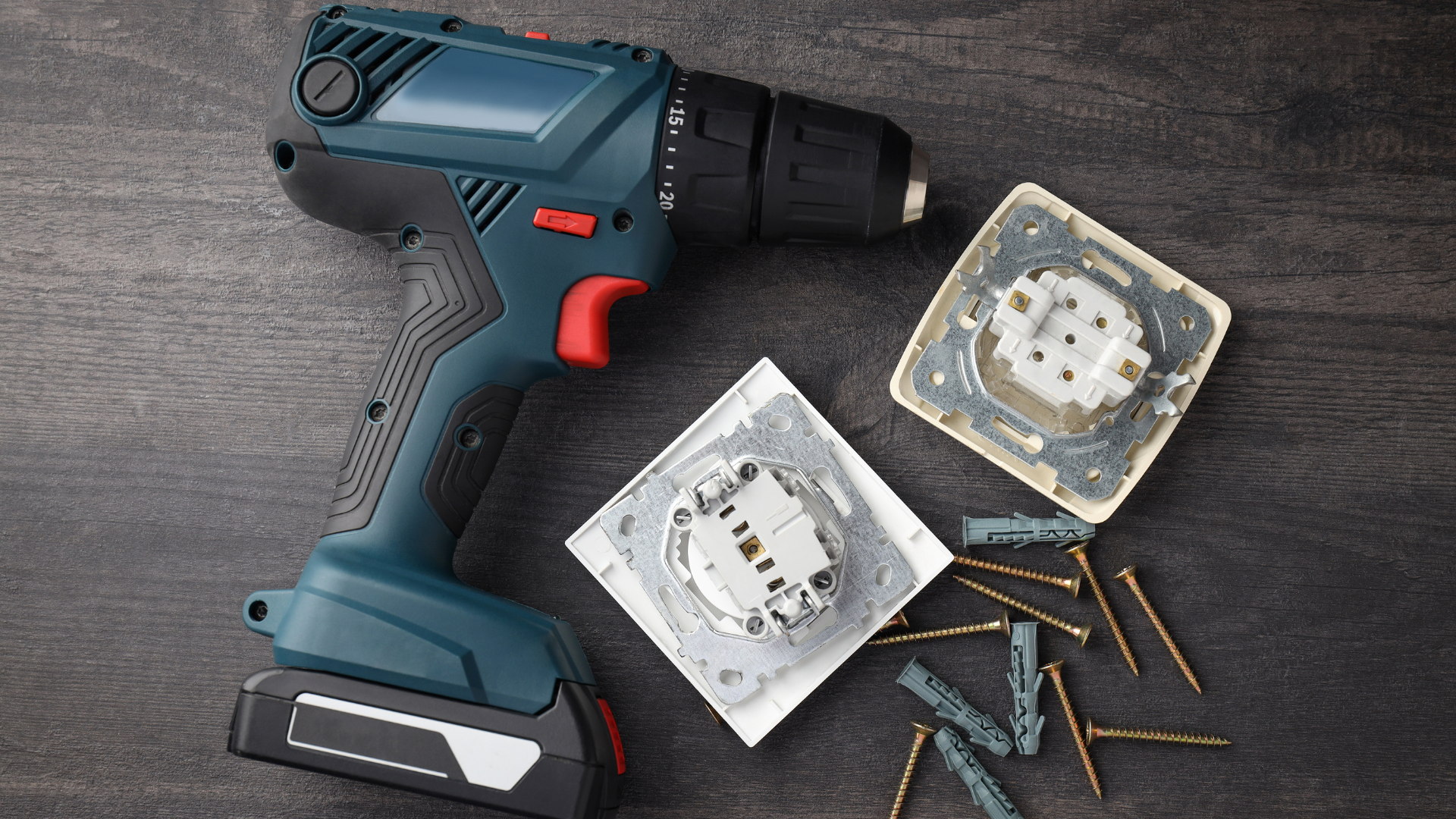 A cordless drill is sitting on a wooden table.