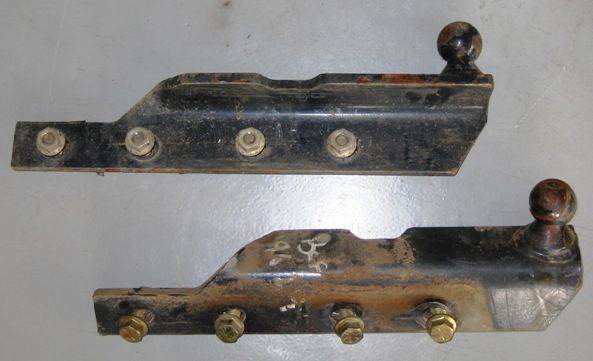 Two pieces of metal are sitting on a white surface.