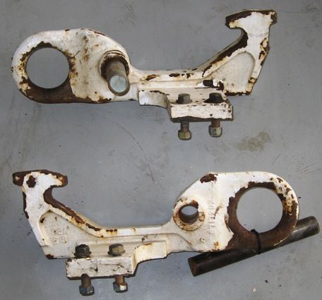 A pair of white metal pieces with holes in them