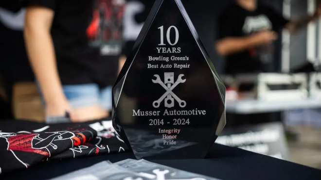 Black award for Massey Automotive's 10th anniversary. Features text and a wrench logo on a table. | Musser Automotive